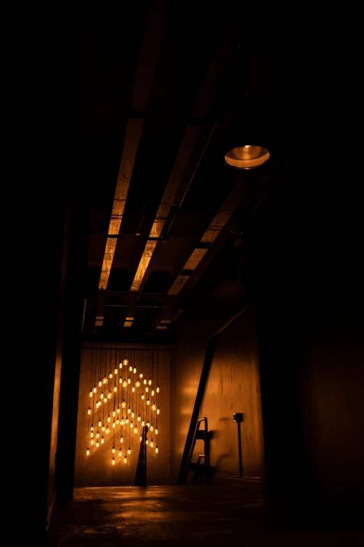 a person standing in a dimly lit room, inspired by Elsa Bleda, kinetic art, theater access corridor, decorations, production photo, candle lit