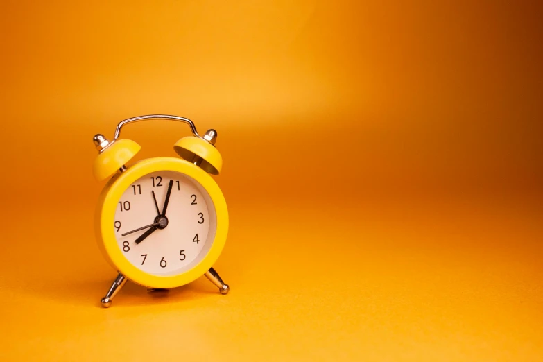 a yellow alarm clock on a yellow background, trending on pixabay, minimalism, orange backgorund, thumbnail, time + space + reality, midnight hour