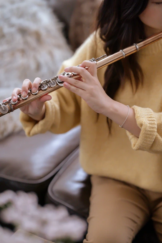 a woman sitting on a couch playing a flute, trending on pexels, arabesque, neck zoomed in, japanese collection product, casually dressed, soft and warm