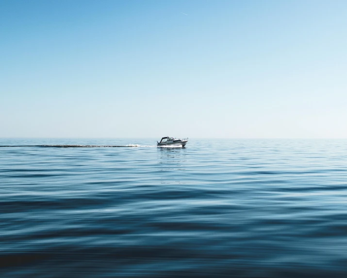 a boat floating on top of a body of water, pexels contest winner, minimalism, blue and clear sky, trailing off into the horizon, subtle detailing, dingy