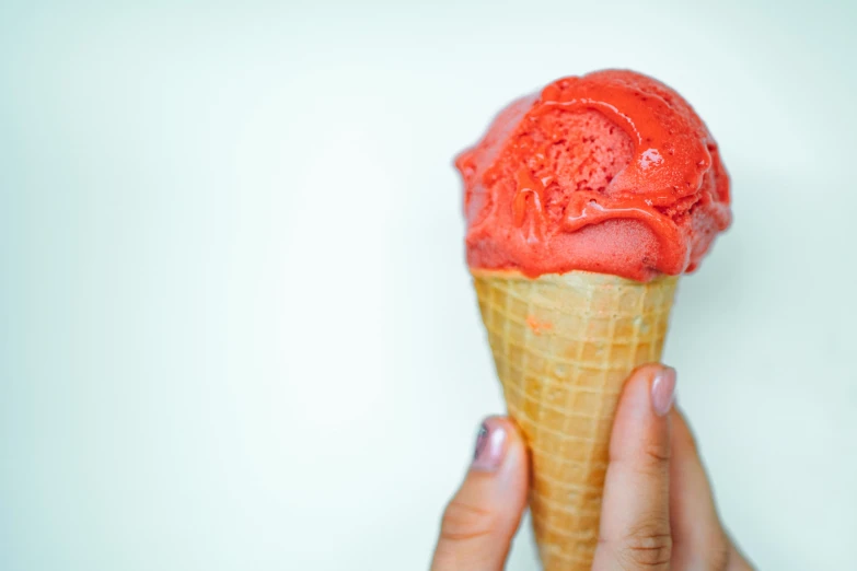 a close up of a person holding an ice cream cone, pexels, coral red, epicurious, shiny crisp finish, ivy's