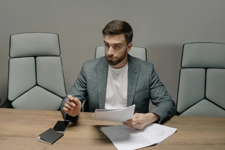 a man sitting at a table with papers and a cell phone, anton fadeev 8 k, avatar image, office clothes, instagram picture