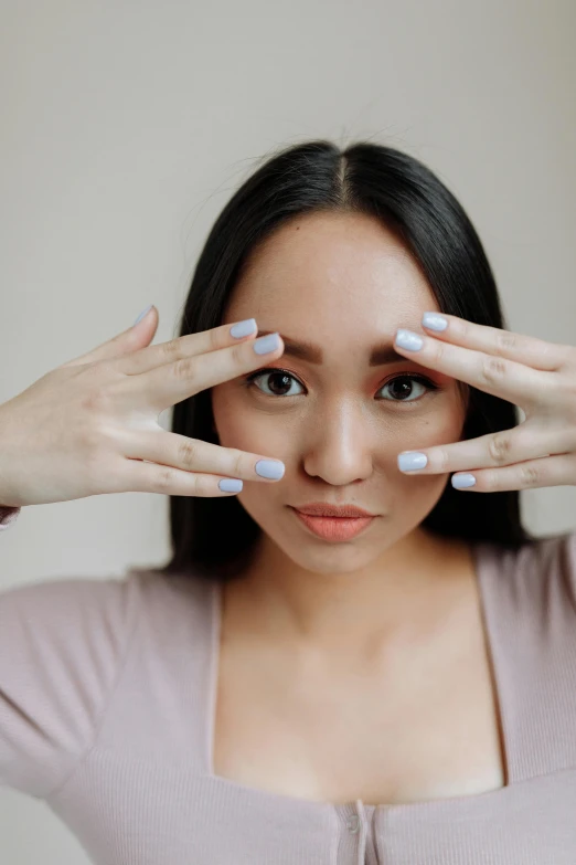 a woman covering her eyes with her hands, trending on pexels, aestheticism, korean symmetrical face, photoshoot for skincare brand, lovingly looking at camera, square facial structure