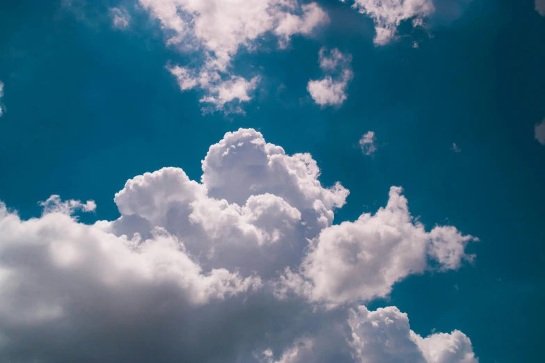 a plane flying through a cloudy blue sky, unsplash, minimalism, cumulus cloud tattoos, multiple stories, show from below, cotton candy clouds