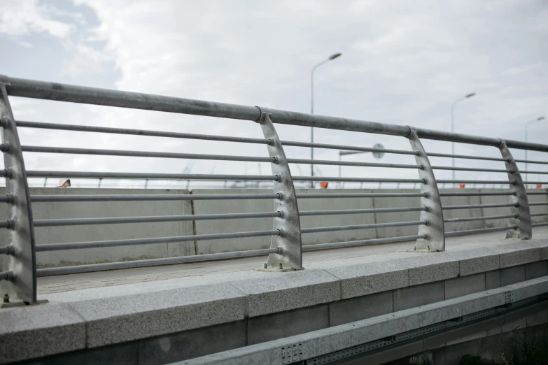 a man riding a skateboard on top of a bridge, inspired by Peter de Sève, gray concrete, ( ( railings ) ), stainless steel, neo norilsk