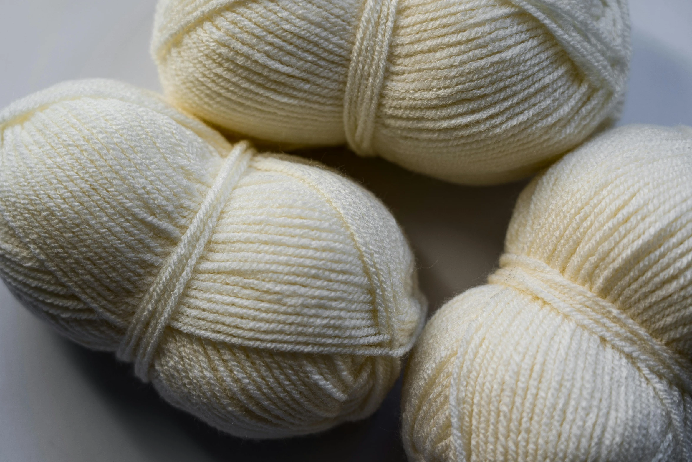 three balls of white yarn on a white surface, a portrait, unsplash, cream of the crop, intarsia, 4 0 9 6, detail shot