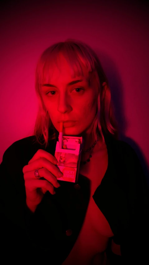 a woman holding a cigarette in front of a pink wall, an album cover, inspired by Nan Goldin, pexels contest winner, dollar bill, portrait of kim petras, holding a drink, high red lights