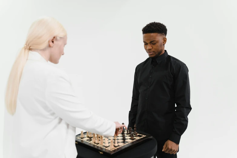 a man and a woman playing a game of chess, by Emma Andijewska, pexels contest winner, kinetic art, black teenage boy, wearing lab coat, set against a white background, on display