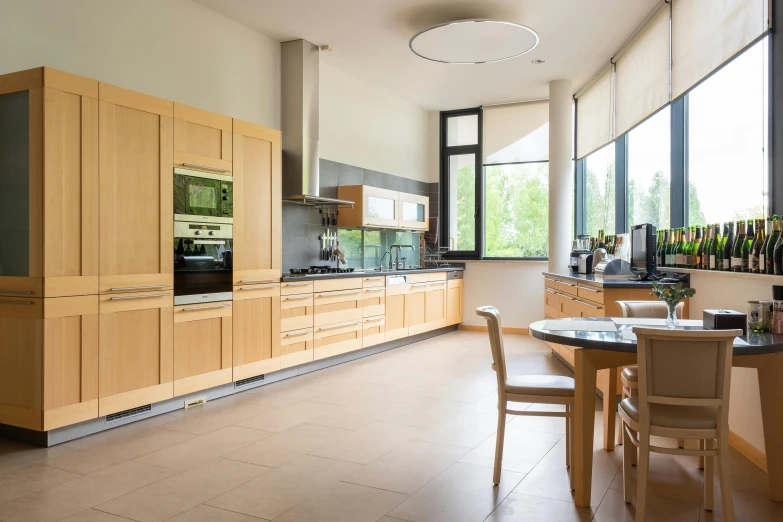 a kitchen with a table and chairs in it, a picture, unsplash, light and space, many large green windows, wood cabinets, luxury bespoke kitchen design, wide - angle view