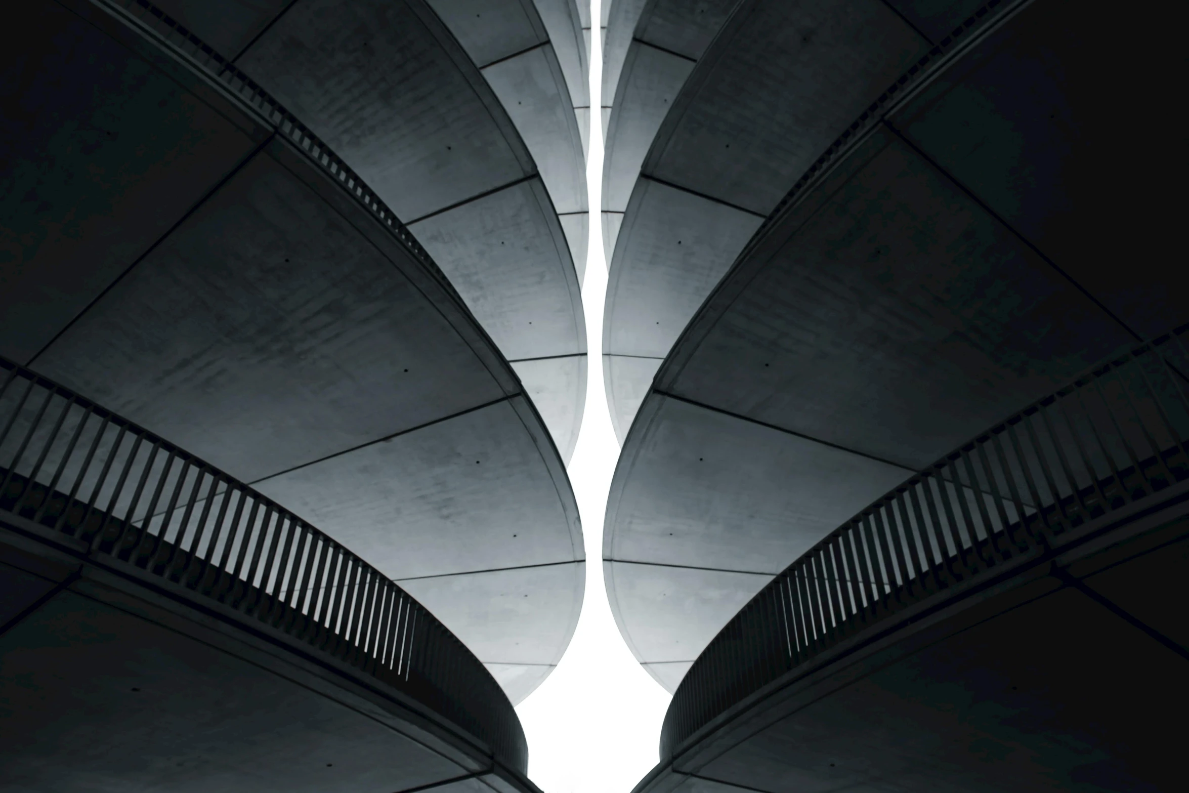 a black and white photo of the underside of a bridge, inspired by Zaha Hadid, unsplash contest winner, brutalism, symmetrical dragon wings, alessio albi, multiple levels, portrait photo