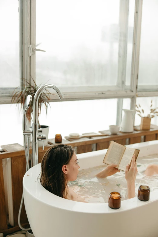 a woman sitting in a bathtub reading a book, pexels contest winner, modernism, escaping air bubbles, sustainable materials, hot tub, low quality photo