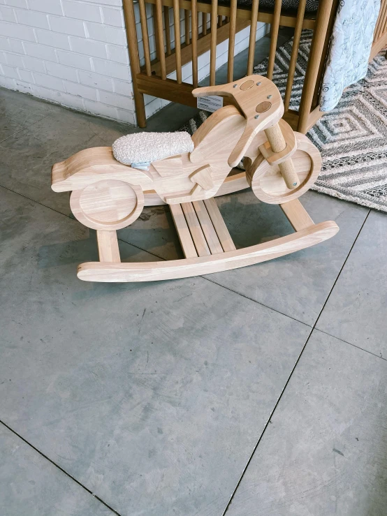 a wooden rocking horse in a living room, by Robbie Trevino, motorbike, natural wood top, vanilla, 15081959 21121991 01012000 4k