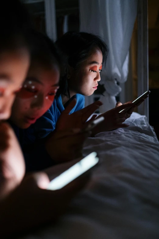 a group of people sitting on top of a bed next to each other, a cartoon, trending on unsplash, happening, thin glowing devices, kids playing, photographed for reuters, chinese