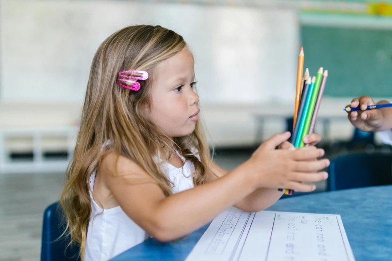 a little girl sitting at a table with colored pencils, pexels contest winner, standing in class, colourised, thumbnail, multiple stories
