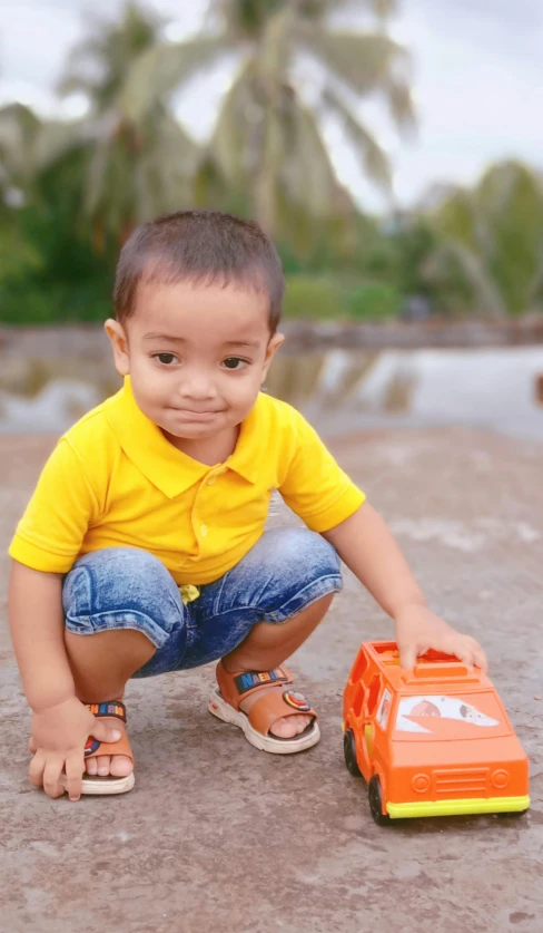 a young boy playing with a toy truck, a picture, by Abidin Dino, pexels contest winner, wearing yellow croptop, avatar image, outdoor photo, 15081959 21121991 01012000 4k