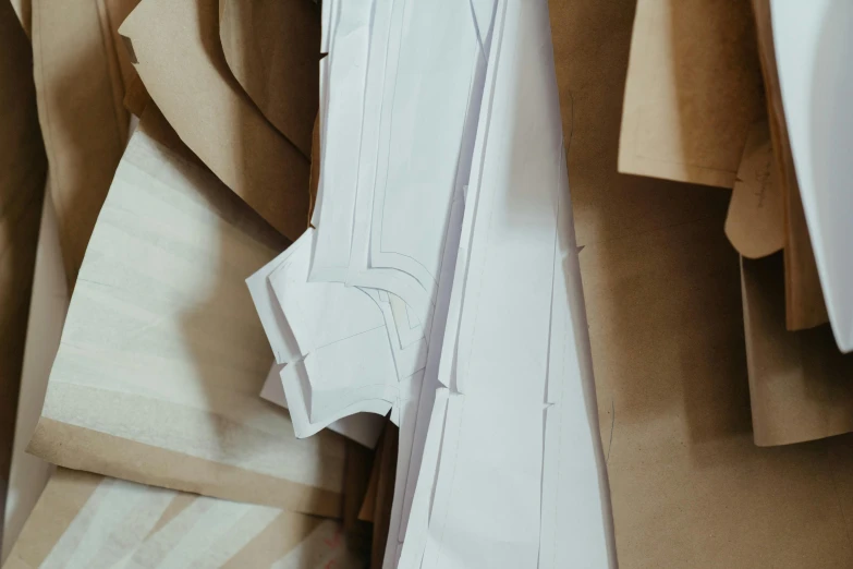 a pair of scissors sitting on top of a piece of paper, an abstract sculpture, by Carey Morris, trending on pexels, arts and crafts movement, in a flowing white tailcoat, cut out of cardboard, smooth panelling, section model