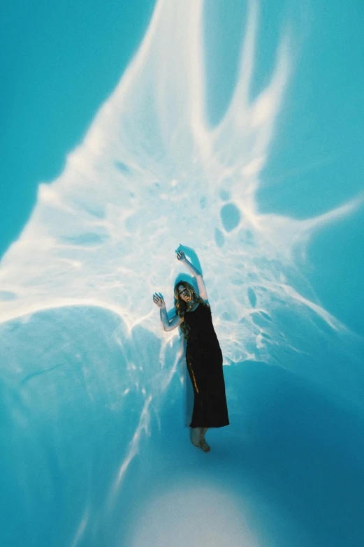 a woman standing on top of a snow covered slope, inspired by Ren Hang, unsplash contest winner, conceptual art, bubbly underwater scenery, light blue water, water gushing from ceiling, fluid bag