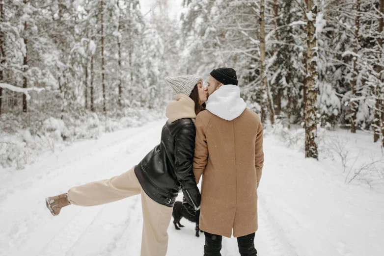 a man and a woman kissing in the snow, pexels contest winner, enjoying a stroll in the forest, leather clothing, thumbnail, back