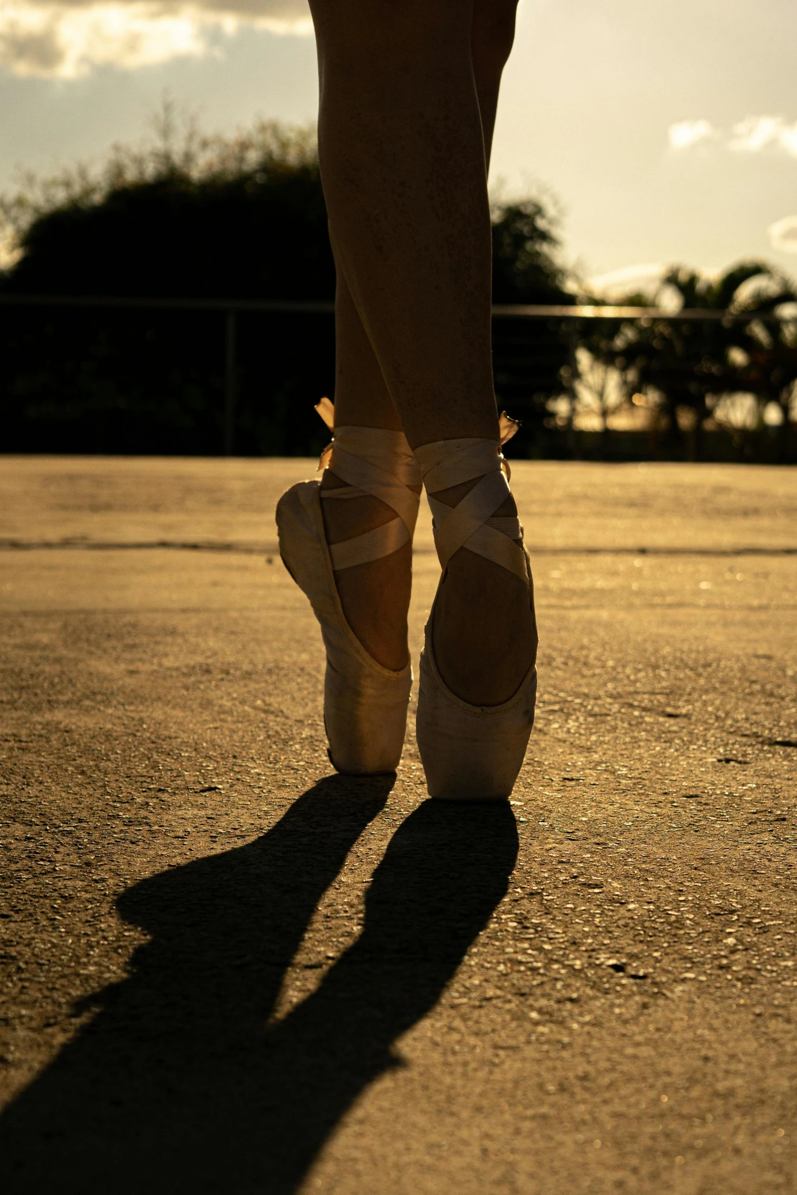 a close up of a person wearing ballet shoes, by Samuel Birmann, unsplash, arabesque, evening sun, cuba, made of glazed, outside in parking lot