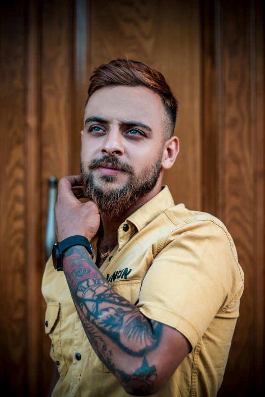 a man with a beard wearing a yellow shirt, a tattoo, trending on pexels, attractive androgynous humanoid, artem chebokha, transgender, 2019 trending photo