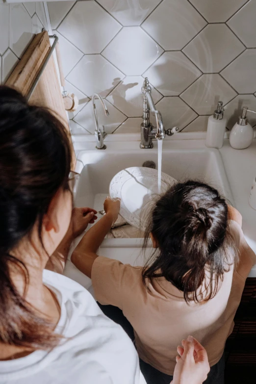 a woman and a child washing their hands in a sink, by Elizabeth Durack, pexels contest winner, flatlay, profile image, hispanic, bedhead