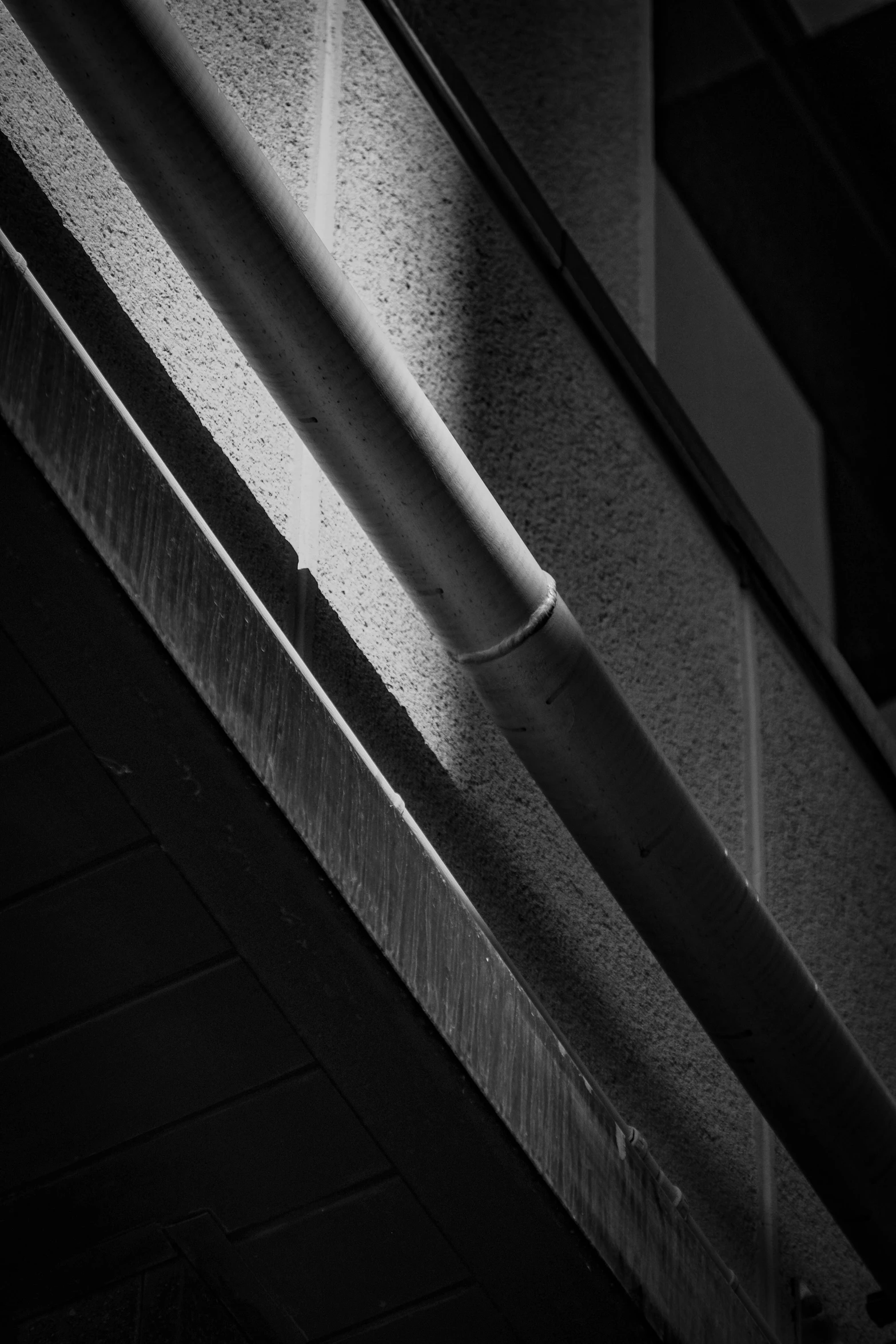 a black and white photo of the corner of a building, unsplash, lyrical abstraction, drainpipes, in a japanese town at night, square lines, 2 4 mm iso 8 0 0 color