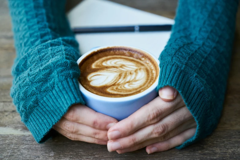 a close up of a person holding a cup of coffee, inspired by Lubin Baugin, cosy vibes, crossed arms, teal aesthetic, cappuccino