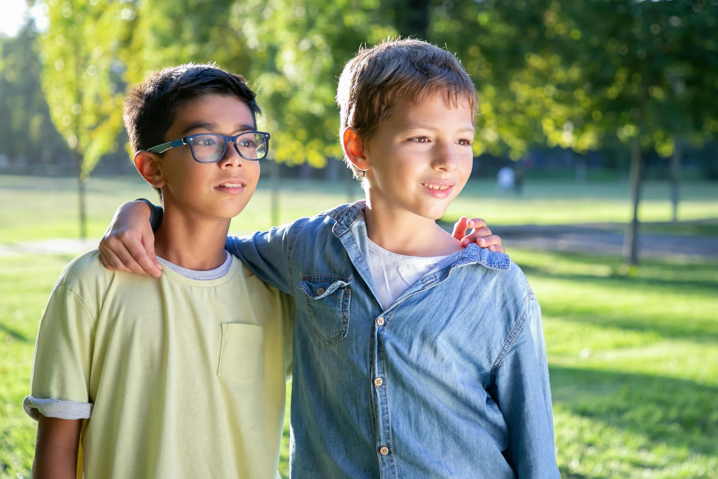 two young boys standing next to each other in a park, a picture, shutterstock, square rimmed glasses, portrait image, schools, wholesome