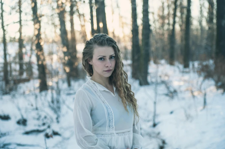 a woman in a white dress standing in the snow, a portrait, inspired by Elsa Bleda, pexels contest winner, avatar image, blonde braids and blue eyes, vintage color, casual photography