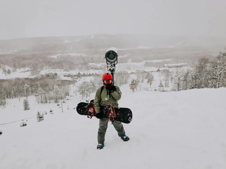 a man holding a snowboard on top of a snow covered slope, trending on vsco, cornell, holding helmet, 8k octan photo