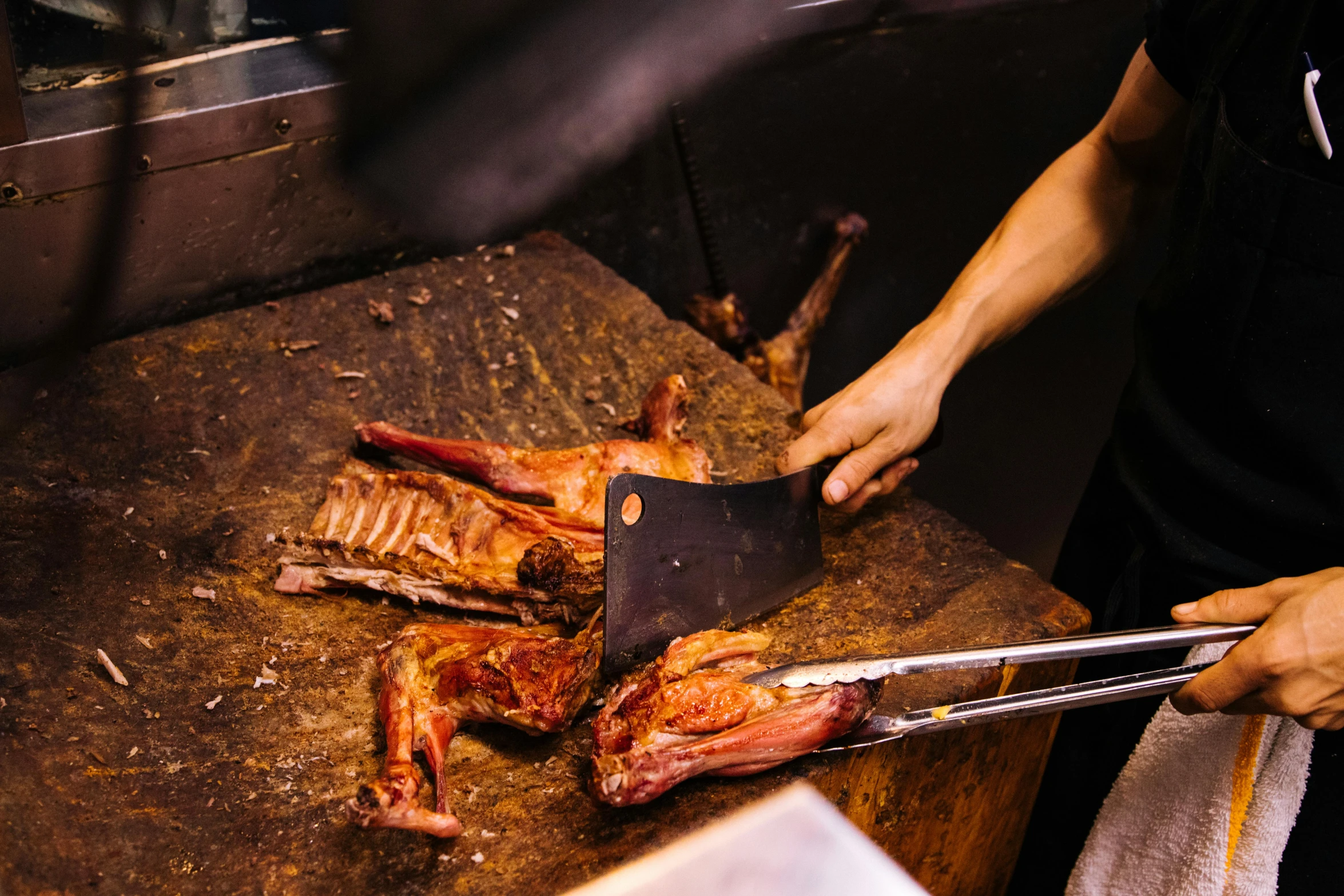 a close up of a person cutting meat on a cutting board, by Julia Pishtar, pexels contest winner, hurufiyya, holding a goat head staff, smoked layered, asian origin, bear legs