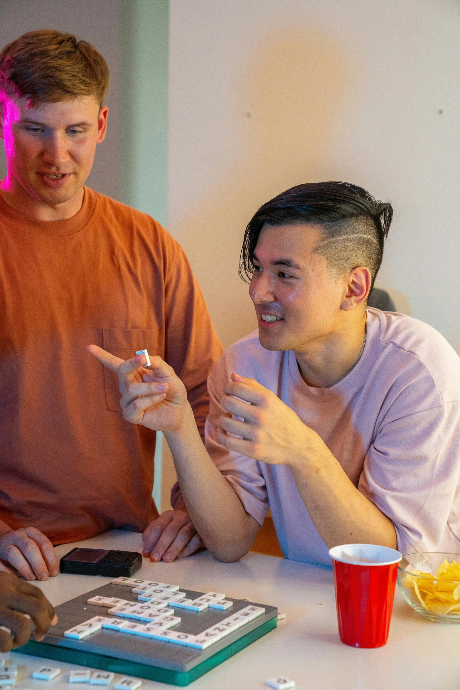 a group of people sitting around a table playing a game, lee madgwick & liam wong, offering the viewer a pill, queer, profile pic