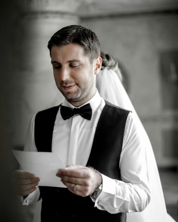 a man in a tuxedo reading a piece of paper, by Lucia Peka, pexels contest winner, happy couple, prideful look, instagram story, ivan aivazovski