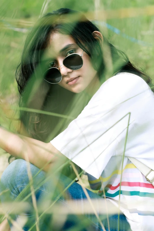 a woman sitting in the grass with a cell phone, by Basuki Abdullah, wear ray - ban glass, ulzzang, cottagecore hippie, !!! colored photography