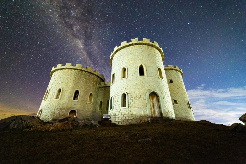 a castle sitting on top of a hill under a night sky, camera obscura, white stone arches, lachlan bailey, ultrawide image