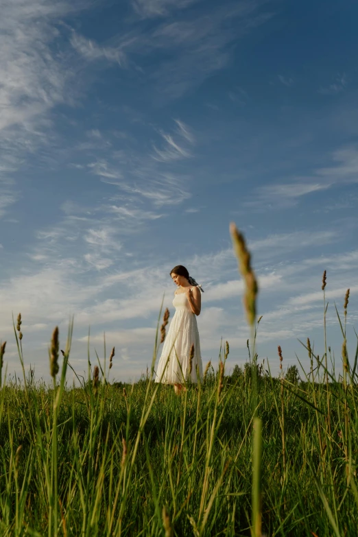 a woman standing on top of a lush green field, inspired by Andrew Wyeth, unsplash, renaissance, wedding, summer evening, white, high-resolution photo