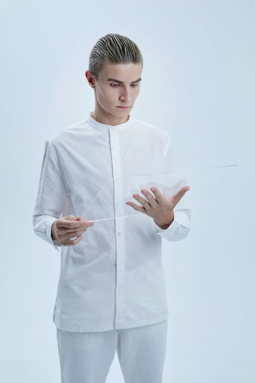 a man in a white shirt and white pants, inspired by Fei Danxu, kinetic art, holding a magic needle, transparent labs, long shirt, official product photo