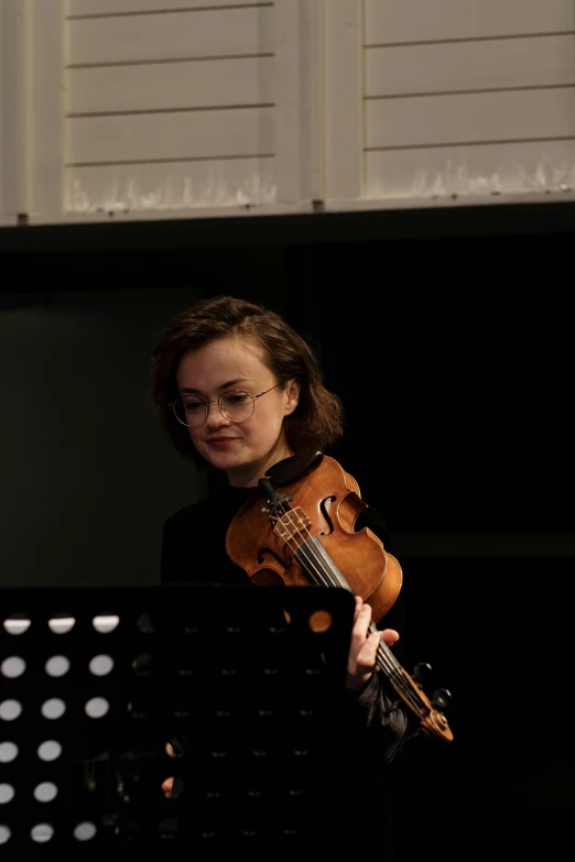 a woman holding a violin on a stage, by Arabella Rankin, slight overcast lighting, square, sydney hanson, taran fiddler