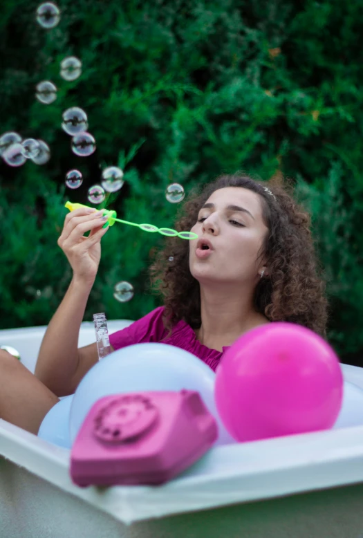 a woman blowing bubbles while sitting in a bathtub, a picture, trending on pexels, party balloons, outdoor photo, curls, square