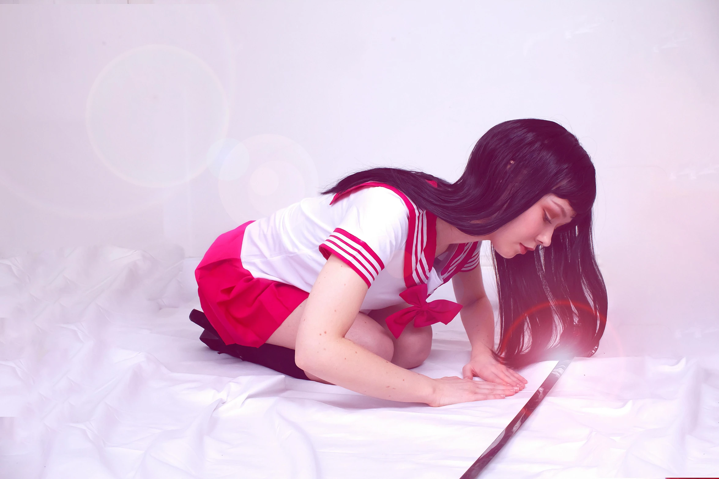a woman laying on top of a bed next to a knife, by Jin Homura, sailor uniform, super realistic photo, gif, taken with sony alpha 9