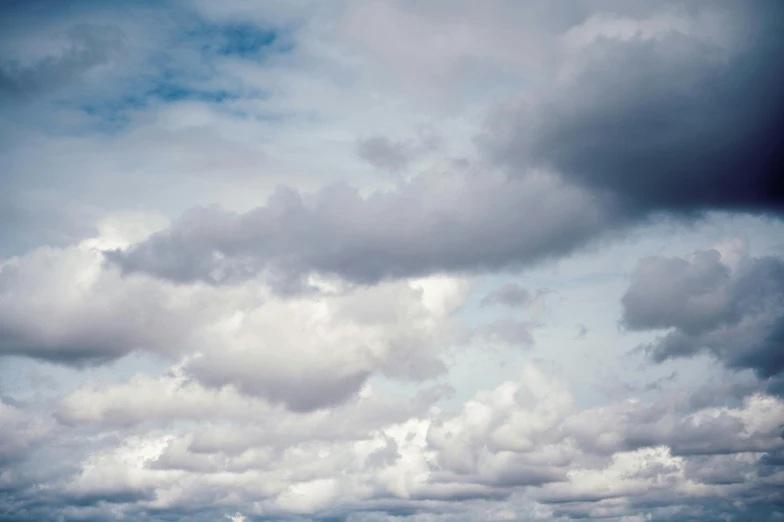 a man flying a kite on top of a lush green field, inspired by Elsa Bleda, unsplash, minimalism, layered stratocumulus clouds, grey, close - up photograph, light blues