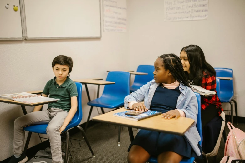 a group of children sitting at desks in a classroom, by Carey Morris, pexels contest winner, calmly conversing 8k, bay area, background image, full body image