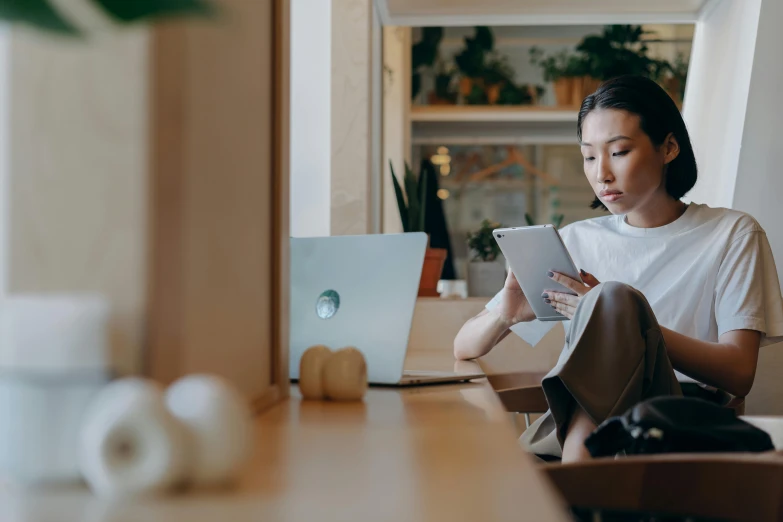 a woman sitting in front of a laptop computer, trending on pexels, japanese collection product, hovering indecision, people sitting at tables, holding notebook