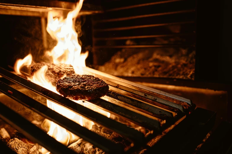 a piece of meat is cooking on a grill, by Joe Bowler, pexels contest winner, dramatic fire lighting, caulfield, serving burgers, avatar image