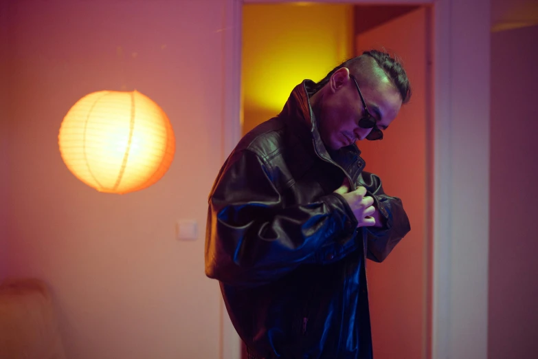 a man in a leather jacket standing in a room, an album cover, inspired by Henri-Julien Dumont, unsplash, bauhaus, 8 0 s asian neon movie still, bad bunny, making of, soft lighting |