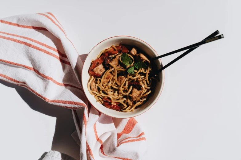 a bowl of noodles and chopsticks on a table, by Emma Andijewska, pexels contest winner, minimalism, ratatouille style, mapo tofu, black on white background, scarf made from spaghetti