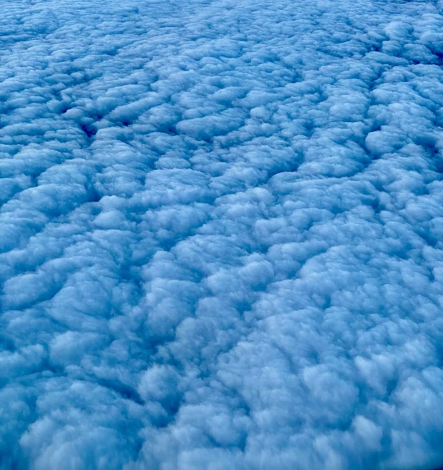 a view of clouds from an airplane window, an album cover, by Matt Cavotta, pexels, blue fur, textured like a carpet, foamy bubbles, closeup shot