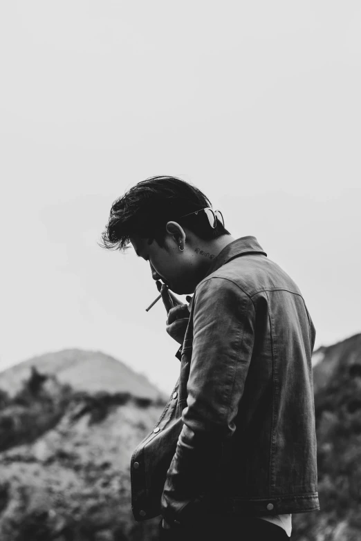 a black and white photo of a man smoking a cigarette, pexels contest winner, aestheticism, on a hill, asian male, music album art, heartbroken