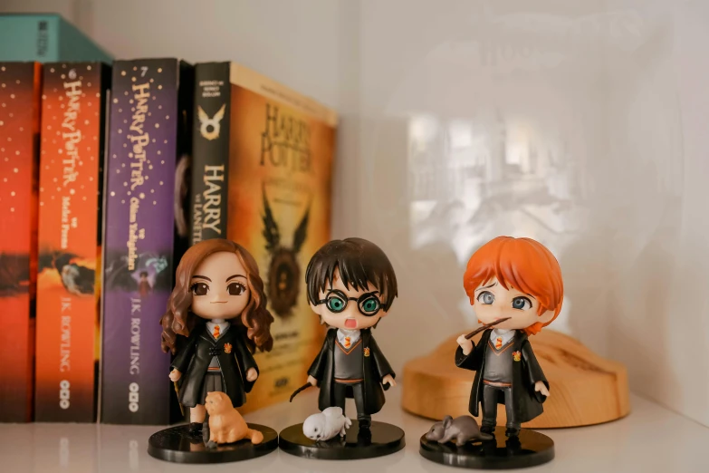 three figurines of harry potter and hermione potter potter potter potter potter potter potter potter potter potter potter potter potter potter potter potter potter, a cartoon, pexels contest winner, wearing black robe, mini model, home display, illustration!