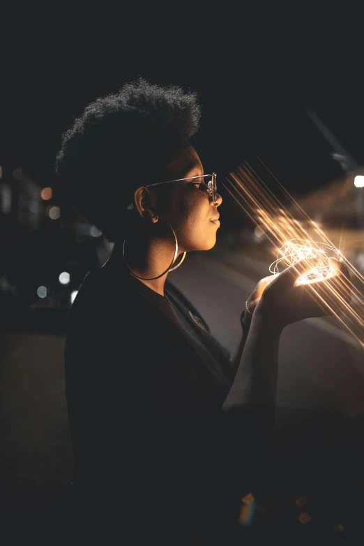 a woman looking at her cell phone in the dark, pexels contest winner, afrofuturism, holding fire and electricity, reflected light, transparent background, profile photography